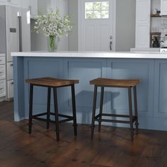 two wooden stools sitting in front of an island