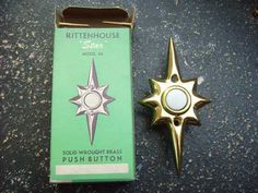 a gold colored pin with a white star on the front and green box next to it