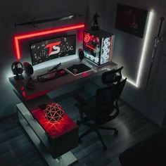 a desk with a computer on it and red lights in the room around it is lit up