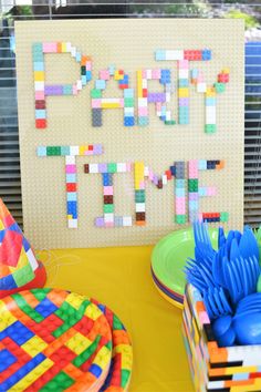 there is a sign made out of legos on the table with plates and forks