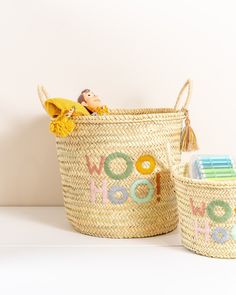 two baskets with the word woo hoo painted on them, one has a doll in it