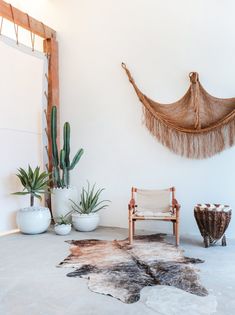 a living room filled with lots of furniture and plants on top of a white floor