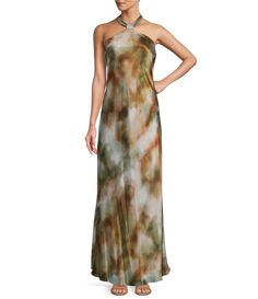 a woman wearing a long dress with a halter neckline and tie dye on it