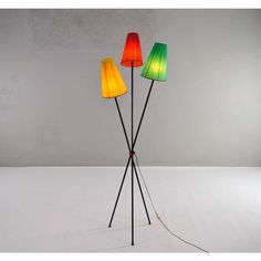 three colorful lamps sitting on top of a white floor