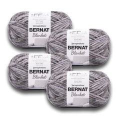 three skeins of bernat wool yarn in grey and white, on a white background