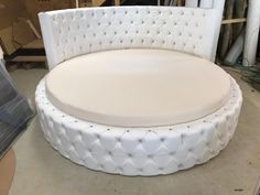 a white round couch sitting on top of a table