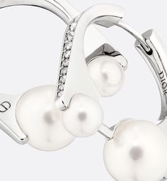 a pair of earrings with white pearls and diamonds on the end of each earring