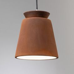 a brown light hanging from a ceiling with a white wall in the background and an orange lamp below it