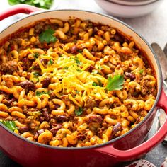 chili macaroni and cheese in a red pot with spoons on the side