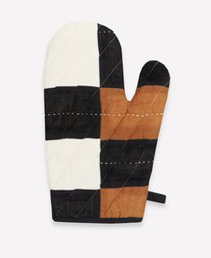 a oven mitt made out of black, white and brown fabric with stitching