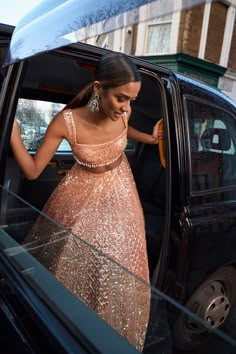 a woman in a dress stepping out of a car