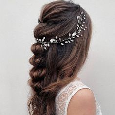 a woman with long hair wearing a headpiece made of flowers and leaves in her hair