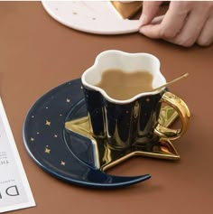 a coffee cup sitting on top of a blue saucer next to a piece of paper