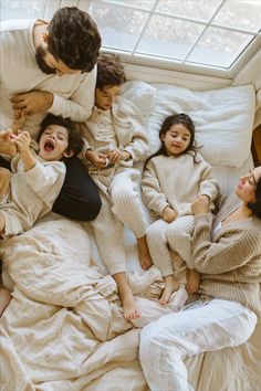 a group of people laying on top of a bed