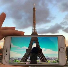 someone taking a photo of the eiffel tower with their cell phone