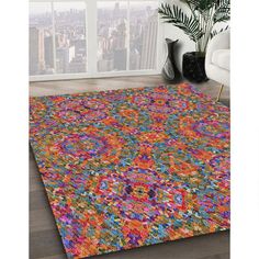 an area rug with multicolored flowers on the floor and in front of a window