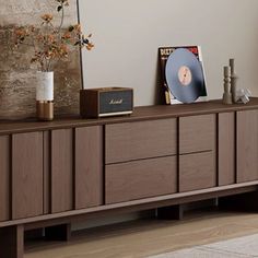 an entertainment center in a living room with various items on the top and bottom drawers