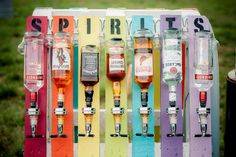 several different types of liquor bottles lined up in a row on a wooden crate with the word spirits painted on it