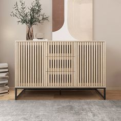 a wooden cabinet sitting on top of a rug next to a vase filled with flowers