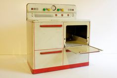 an old fashioned oven with its door open on a white surface, showing the interior