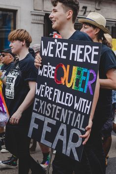 a group of people walking down the street holding signs