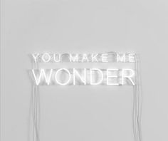 a sign that says you make me wonder hanging on the side of a white wall