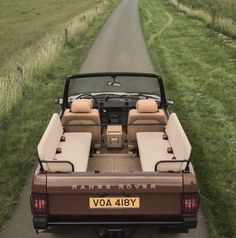 a car parked on the side of a road with two seats in the back and an open hatchback