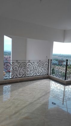 an empty room with white walls and tile flooring, looking out onto the city