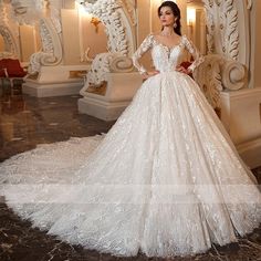 a woman in a white wedding dress standing next to a wall with ornate carvings on it