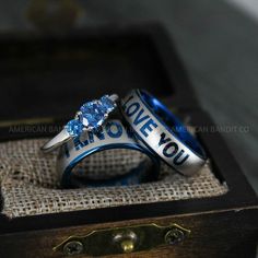 two wedding rings sitting on top of each other in front of an old wooden box