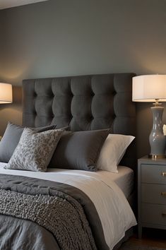 a bed with pillows, blankets and lamps in a bedroom