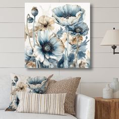 a living room scene with focus on the blue flowers and white wall art above the couch