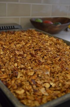 a pan filled with granola sitting on top of a counter next to a bowl