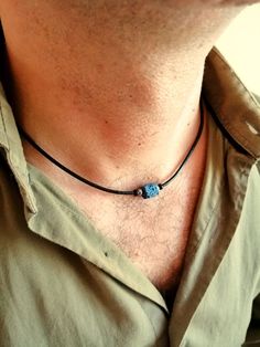 "Mens choker necklace in minimalist style made with natural lava stone bead blue color, stainless steel rondelle beads and black wood beads on black leather cord, stainless steel lobster clasp closure.  Simple everyday leather rope necklace for men, blue bead choker for him. This minimalist leather necklace will be a perfect gift for him. Necklace length: 18 inches (45 cm) lava stone beads: 10 mm wooden beads: 3 mm Stainless steel beads: 3 mm Lava Stone is a grounding stone that strengthens one's connection to Mother Earth. It gives us strength and courage, allowing us stability through times of change. It provides guidance and understanding in situations where we may need to \"bounce back\". A calming stone, it is very useful in dissipating anger. For all products are used only genuine hi Minimalist Adjustable Lava Stone Jewelry, Minimalist Blue Jewelry With Adjustable Cord, Beaded Necklace For Men, Mens Choker Necklace, Leather Beaded Necklace, Perfect Gift For Him, Rope Necklace, Lava Stone, Men's Necklace