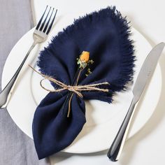 a white plate topped with a blue napkin and fork