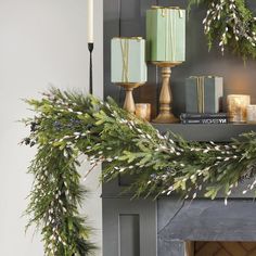 a christmas mantle decorated with greenery and candles