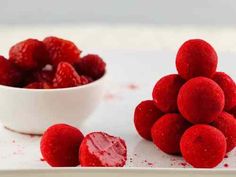 some raspberries are in a white bowl and on a plate next to it