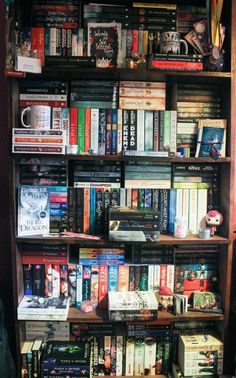 a bookshelf filled with lots of different types of books on top of each other