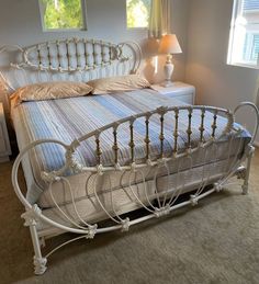 a white bed sitting in a bedroom next to a window