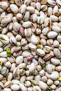 pistachio nuts are scattered on top of each other