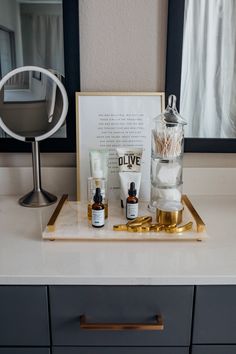 a bathroom counter with various items on it and a framed mirror in the back ground