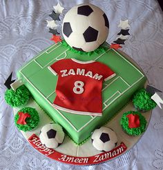 a soccer themed birthday cake on a white tablecloth with an image of a soccer ball and the number eight