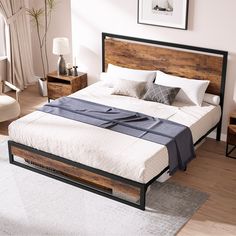 a large bed sitting on top of a wooden floor next to a white rug in a bedroom