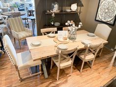 a dining room table with chairs and plates on it in front of a display case