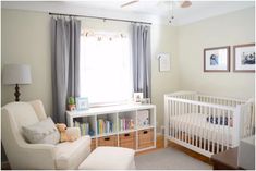 a baby's room with a white crib, bookcase and chair in it