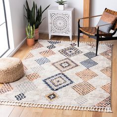 a living room area with a chair, rug and potted plant