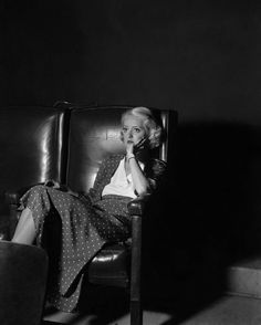 a woman sitting in a chair talking on a cell phone