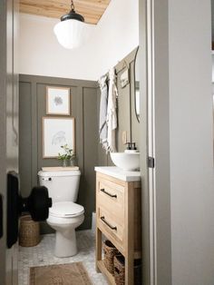 a white toilet sitting in a bathroom next to a wooden cabinet with drawers on it