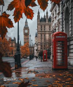 a red phone booth sitting on the side of a road