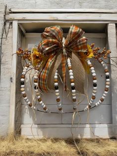 a wreath made out of wood beads and burlocks with a bow on the front door